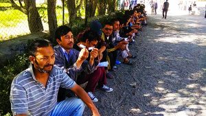 Voters take rest in a long queue as they wait for their turn to cast votes for the LAHDC Kargil on Monday.