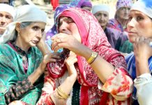 Women wail over the killing of Mushtaq Ahmad at Bomai, Sopore on Monday. -Excelsior/Aabid Nabi