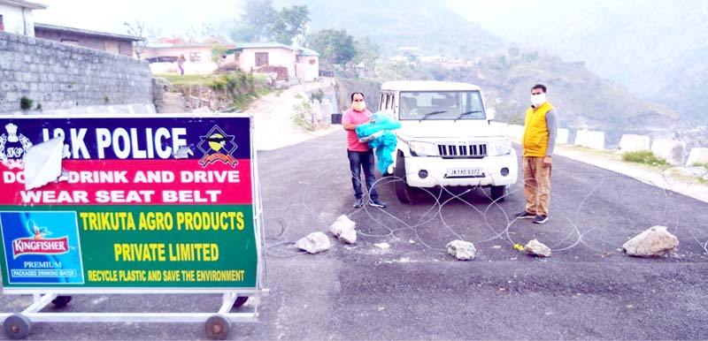 As part of distributing 10000 face masks in BJP Mandal Katra, President Rajinder Mengi handing over cotton cloth to Vice President and Sarpanch of Sundrani Panchayat Pawan Sharma. -Excelsior/Mengi