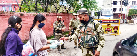 Sewa Bharti members distributing tea and biscuits among security forces personnel. 