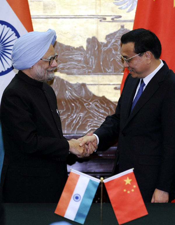 Li Keqiang shakes hands with Manmohan Singh after a joint news conference at the Great Hall of the People in Beijing