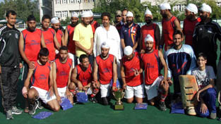 J&K Police Central team players posing for photograph with Minister for Housing Raman Bhalla after winning State Hockey Championship trophy at Jammu on Sunday. -Excelsior/Rakesh