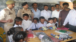 Kids posing for a photograph while receiving sports kits.
