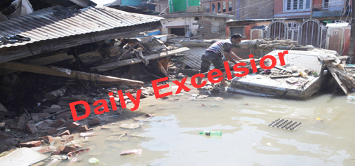 September- 17, 2014- SRINAGAR: A Kashmiri man cleaning his car damaged by flooding outskirts of Srinagar, on Wednesday. Photo/Mohd Amin War