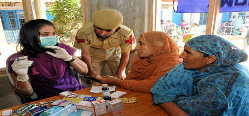 A doctor with face mask attends patients at a free medical camp organised by BSF in Srinagar on Monday. —Excelsior/Amin War