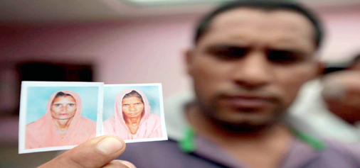 A relative displays pictures of two women killed in Pakistan shelling at Chilyari in Samba sector on Wednesday. -Excelsior/Rakesh