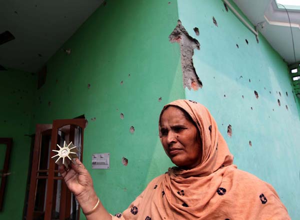 A woman stands in front of her badly damaged house, which was hit by mortar shells and bullets at Kaku-De-Kothe in Arnia sector on Saturday. Another pic on page 9. -Excelsior/Rakesh A woman stands in front of her badly damaged house, which was hit by mortar shells and bullets at Kaku-De-Kothe in Arnia sector on Saturday. Another pic on page 9. -Excelsior/Rakesh