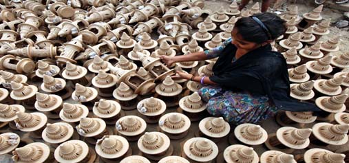 A girl puts earthen temple models, used to worship during Diwali festival, to dry in the Sun at a workshop ahead of Diwali in Chandigarh on Tuesday. (UNI)