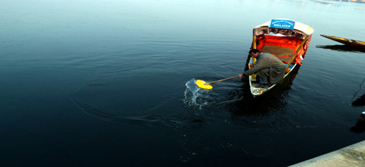 A boatman shows a piece of frozen ice at Srinagar's Dal lake on Sunday. —Excelsior/Amin War