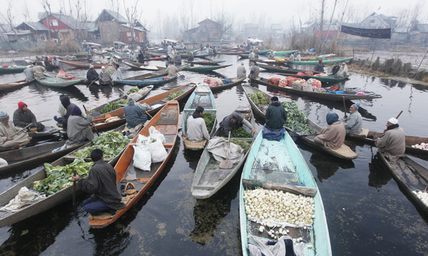Vendors display their wares at an early morning floating vegetable market at Dal lake in Srinagar on Monday. -Excelsior/Amin War