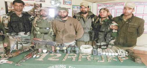 Security personnel pose with arms and ammunition seized in Banihal on Tuesday.