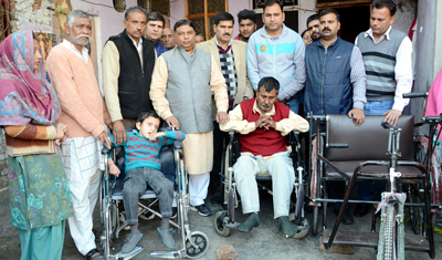 Sat Sharma handing over wheel chair and a tricycle to differently abled person and a child at Puran Nagar, Jammu on Wednesday. Sat Sharma handing over wheel chair and a tricycle to differently abled person and a child at Puran Nagar, Jammu on Wednesday.