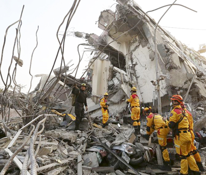 Rescue personnel work at the site where a 17-storey apartment building collapsed, after an earthquake in Tainan
