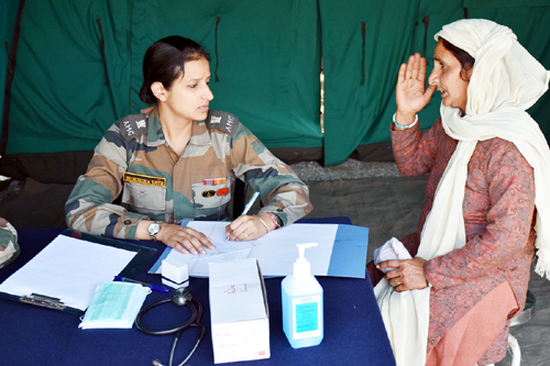 An Army doctor prescribing medicines to a patient during a medical camp. An Army doctor prescribing medicines to a patient during a medical camp.