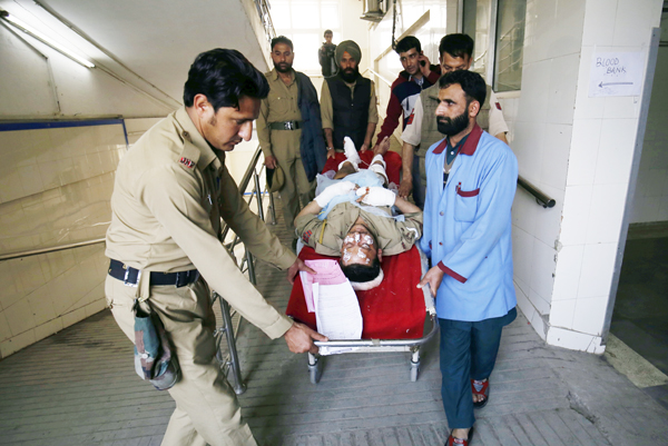Cops and paramedics carry a policeman injured in grenade attack for treatment at a local hospital in Srinagar on Friday. — Excelsior Photo Cops and paramedics carry a policeman injured in grenade attack for treatment at a local hospital in Srinagar on Friday. — Excelsior Photo
