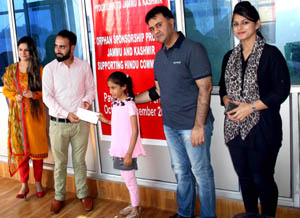 Rayees Ahmad, Sponsorship Manager for Mother Helpage presenting scholarship cheque to a child in presence of Vikram Malhotra, Chairman, Swabhimaan Charitable Trust. Rayees Ahmad, Sponsorship Manager for Mother Helpage presenting scholarship cheque to a child in presence of Vikram Malhotra, Chairman, Swabhimaan Charitable Trust.