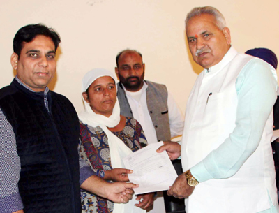PHE Minister, Sham Lal Choudhary distributing financial assistance to shelling hit person at R S Pura on Friday. PHE Minister, Sham Lal Choudhary distributing financial assistance to shelling hit person at R S Pura on Friday.