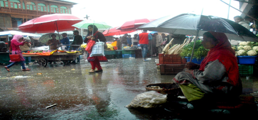 People use umbrellas at a market in Srinagar, as torrential rains lash Kashmir valley on Tuesday. (UNI) People use umbrellas at a market in Srinagar, as torrential rains lash Kashmir valley on Tuesday. (UNI)