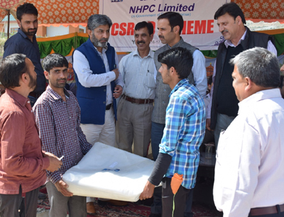 DC Bandipora and NHPC officers distributing aid to villagers. DC Bandipora and NHPC officers distributing aid to villagers.