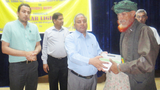 DC Reasi and authorities of NHPC handing over solar light to a beneficiary at Salal on Thursday.