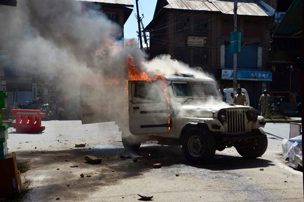 A police vehicle set on fire by angry protesters in Anantnag on Friday. -Excelsior/Sajad Dar A police vehicle set on fire by angry protesters in Anantnag on Friday. -Excelsior/Sajad Dar