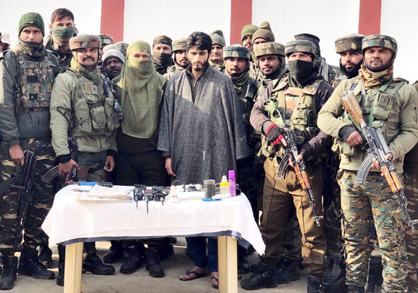 Affaq Ahmad Bhat in Army custody with recoveries in Handwara on Friday. (UNI) Affaq Ahmad Bhat in Army custody with recoveries in Handwara on Friday. (UNI)