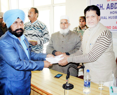 Minister for Animal Husbandry, Abdul Gani Kohli handing over regularization order to ReTs at Rajouri on Tuesday. Minister for Animal Husbandry, Abdul Gani Kohli handing over regularization order to ReTs at Rajouri on Tuesday.