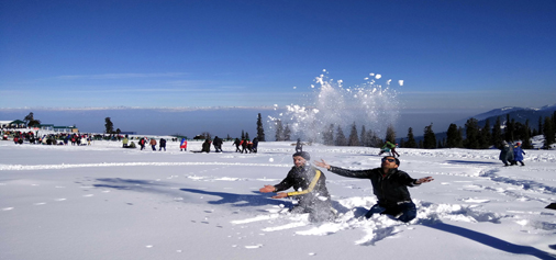Tourists enjoying fresh snowfall at Gulmarg on Thursday.