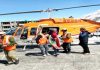 Rescuers helping a lady who was who was among the stranded passengers from a remote Lakhang area of Ladakh region due to heavy snow fall airlifted to hospital in the region on Sunday.