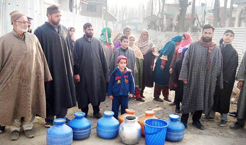 Residents of Rajbagh Mohalla in Sopore protesting with empty pots against PHE Department. Residents of Rajbagh Mohalla in Sopore protesting with empty pots against PHE Department.