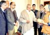 Governor Satya Pal Malik giving away cheque to kin of deceased ASHA worker at Raj Bhavan on Monday.
