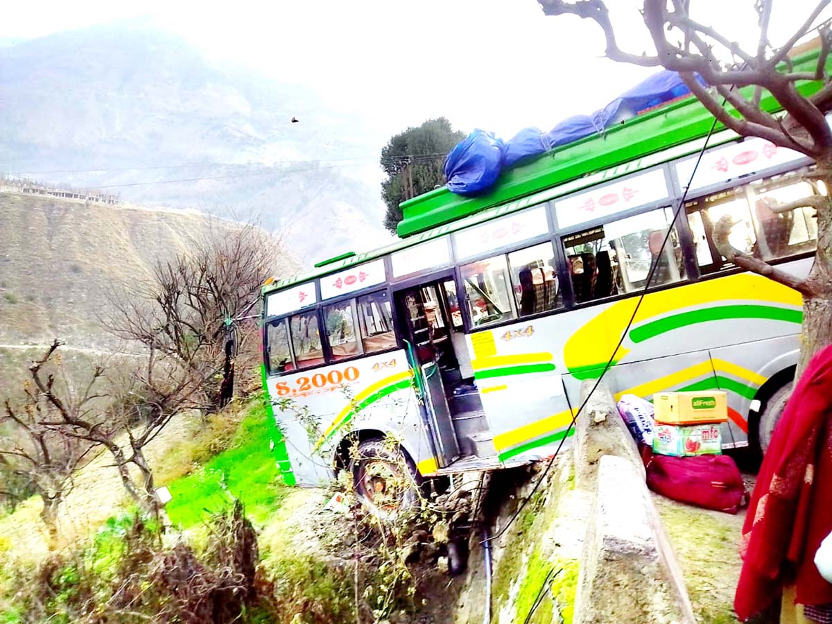 A bus hangs from edge of hill road. A bus hangs from edge of hill road.