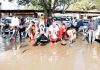 NHM employees removing water stagnated in front of Press Club Jammu during their ongoing protest on Wednesday. -Excelsior/Rakesh