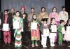 Students in colourful attires posing along with dignitaries during Annual Day celebration at Dogra HSS Shastri Nagar in Jammu.