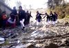 School going children passing through Sounthan road, which has not been repaired for several years.