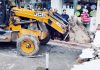 Encroachment being removed with the help of JCB at Udhampur town on Friday.