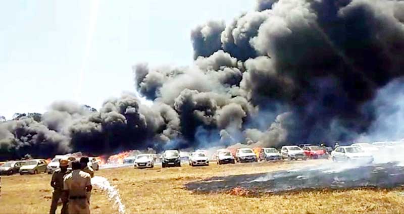 Dark smoke billows after a major fire break out at a parking area near Gate no 5 of Yehlanka airbase, more than 300 cars reportedly burnt, in Bengaluru on Saturday. (UNI) Dark smoke billows after a major fire break out at a parking area near Gate no 5 of Yehlanka airbase, more than 300 cars reportedly burnt, in Bengaluru on Saturday. (UNI)