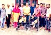 Senior BJP leader and former Minister, Sham Lal Sharma distributing wheelchairs among differently abled students in Raipur Domana on Thursday.