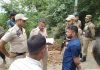 Policemen trying to pacify protesting relatives of deceased woman.