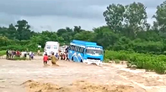 A passenger bus trapped in flash flood at Pacca Kotha on Dayala Chak-Billawar road on Saturday. —Excelsior/Pardeep