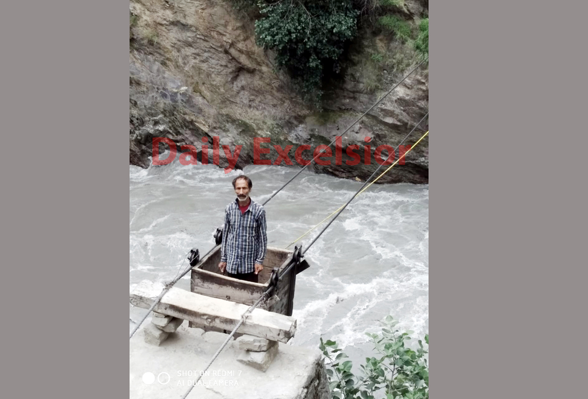 A man of Kontwara area in Kishtwar district crossing the river in a trolley due to failure of Government to construct the bridge.