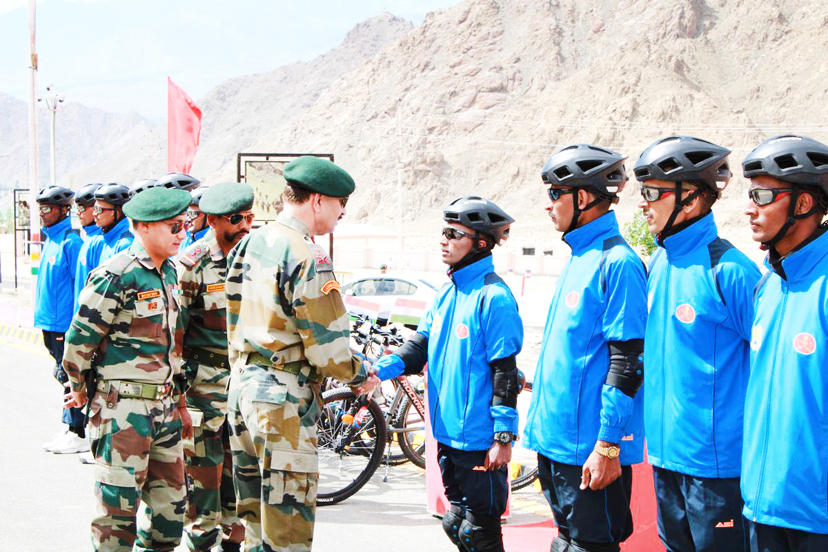 Army officers interacting with cyclists during flag in ceremony of Mountain Terrain Bike expedition.