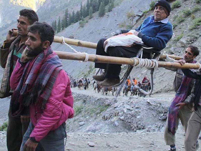 An Amarnath yatri being taken to Cave Shrine in a ‘palki’. -Excelsior/Sajjad Dar An Amarnath yatri being taken to Cave Shrine in a ‘palki’. -Excelsior/Sajjad Dar