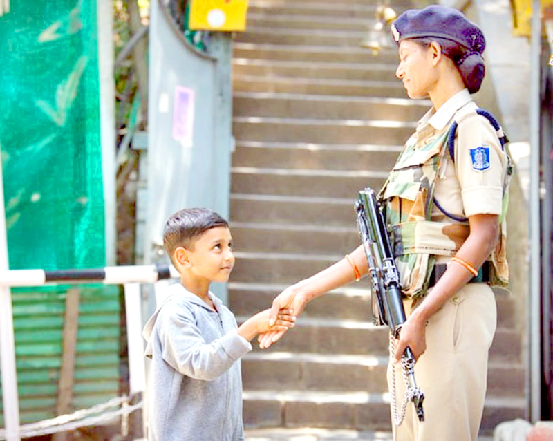 A child shakes hands with woman jawan of CRPF amidst restriction in Kashmir on Thursday. A child shakes hands with woman jawan of CRPF amidst restriction in Kashmir on Thursday.
