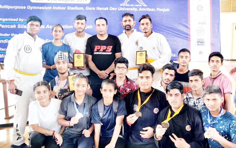 Medal winners of Pencak Silat Championship posing for a group photograph. Medal winners of Pencak Silat Championship posing for a group photograph.
