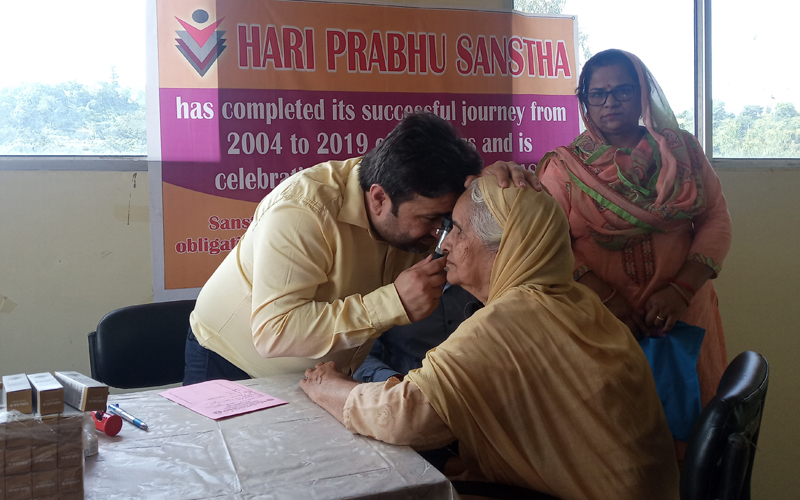 A doctor examining a patient during free eye check up camp. A doctor examining a patient during free eye check up camp.