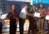 Ravinder Bhat (founder of Road Safety Champions) presenting appreciation certificate to a police officer during an awareness camp on road safety at Bantalab, Jammu.