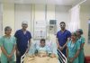 A team of doctors of SMVDNSH posing with a child after successfully performing open heart surgery.