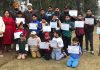 Young golfers holding certificates during Putting contest for children.
