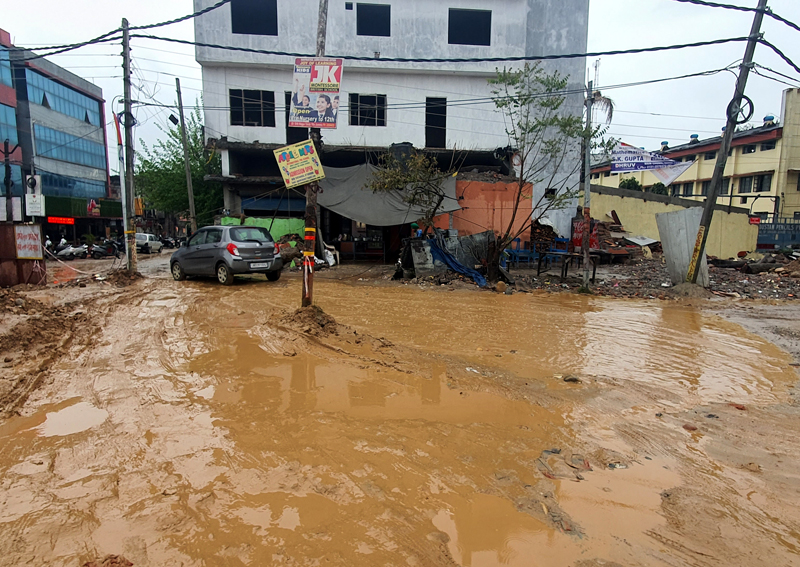 Potholes filled with muddy water because of damaged drainage adjoining the Jammu-Akhnoor road. — Excelsior/Rakesh Potholes filled with muddy water because of damaged drainage adjoining the Jammu-Akhnoor road. — Excelsior/Rakesh